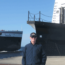 Dennis S. Bernstein standing in front of a ship